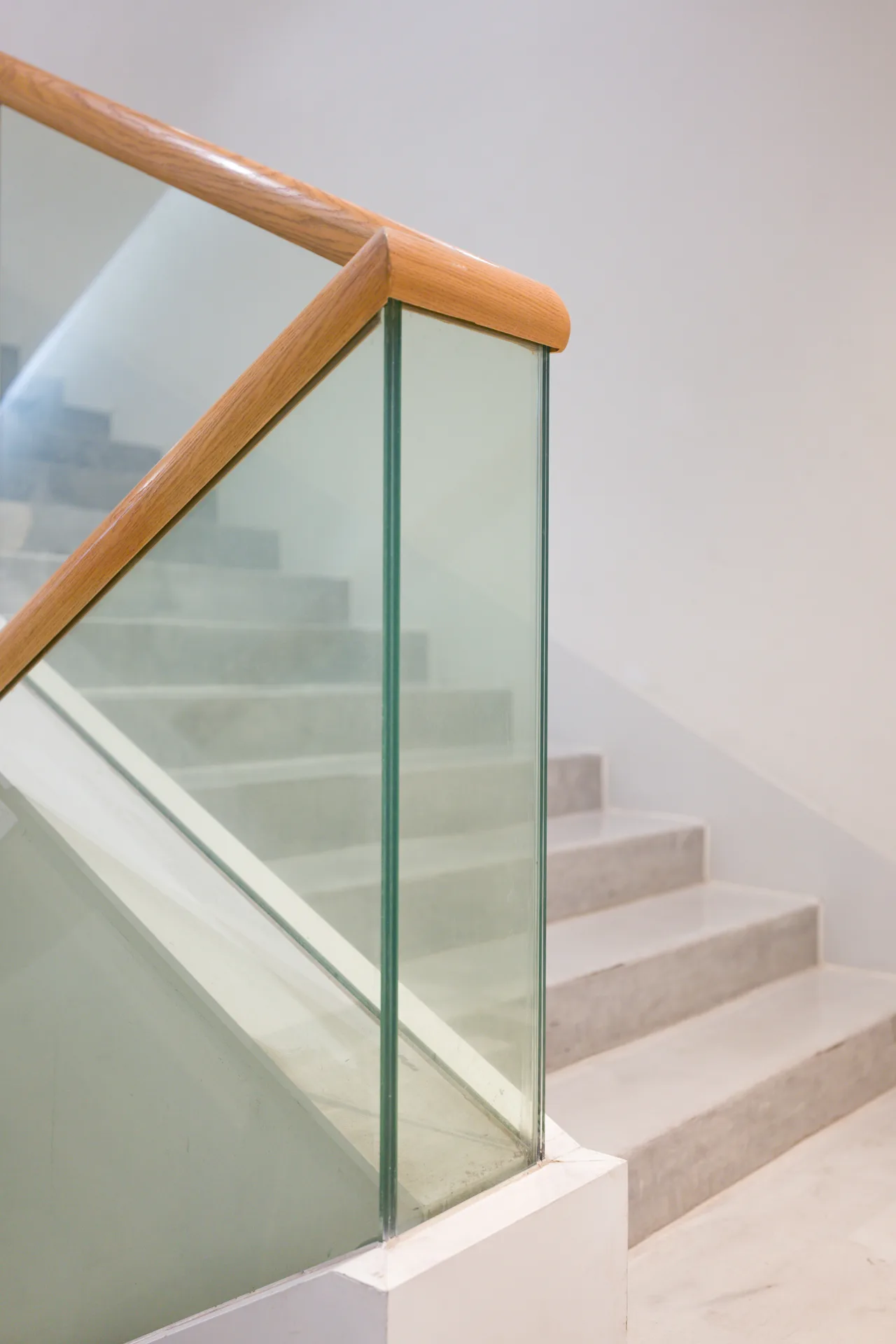 poured concrete staircase with glass railing at a Abbotsford home